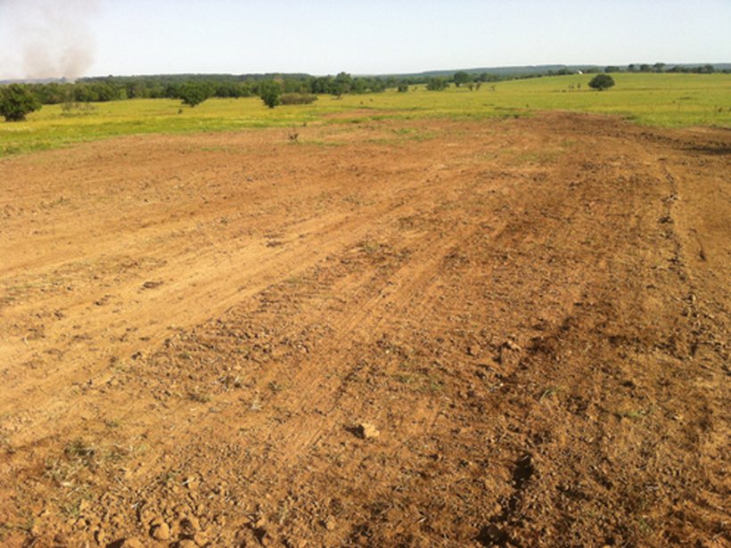 The Clapp spill site weeks after a produced-water spill — a bare, dead scar outlined sharply against the surrounding pasture.