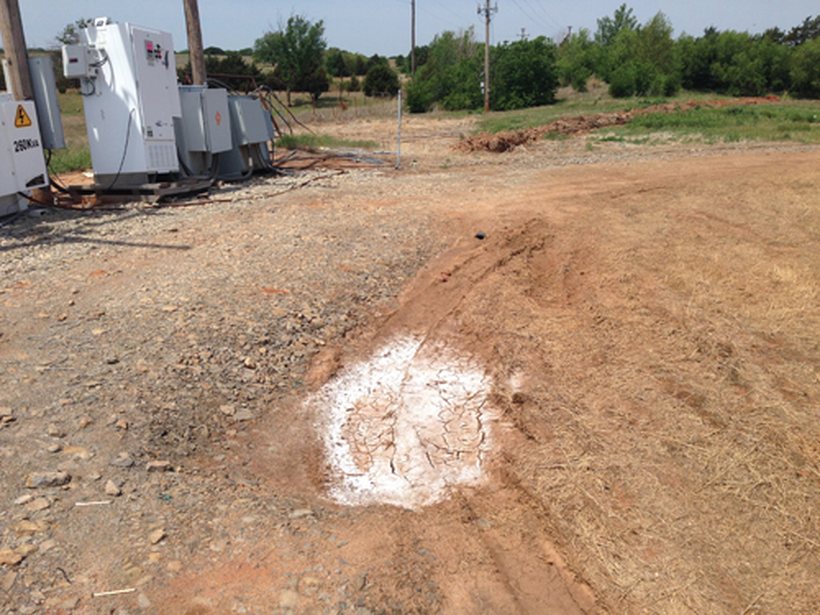 A salt-scalded spot at the Vinco wellsite, crusted white and bare next to the equipment pad.
